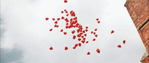Niespodzianka na weselu w postaci balonów unosi się na tle nieba.